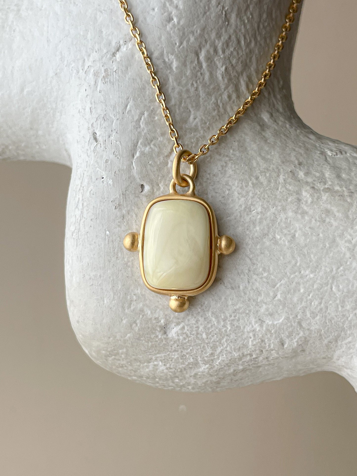 Gold plated pendant with milk amber